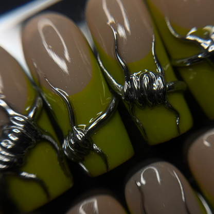 Close-up of press-on nails with a glossy nude-beige top and bright chartreuse green base, decorated with metallic silver barbed wire on the front nails